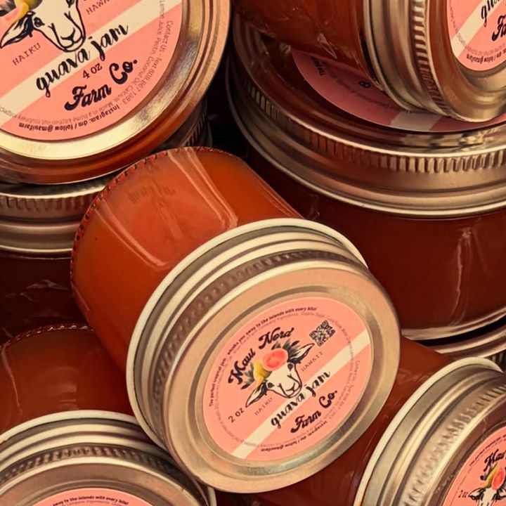 Jars of guava jam stacked at angles, each lid printed with the sheep and wreath mark