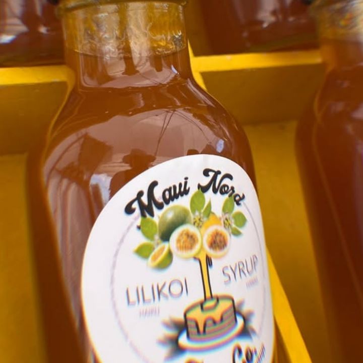 Bottles of lilikoi syrup with the Maui Nord Farm label, in a yellow crate